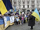 Lidé s ukrajinskými vlajkami a nápisem "Vítejte, prezidente. Sláva Ukrajin" se...