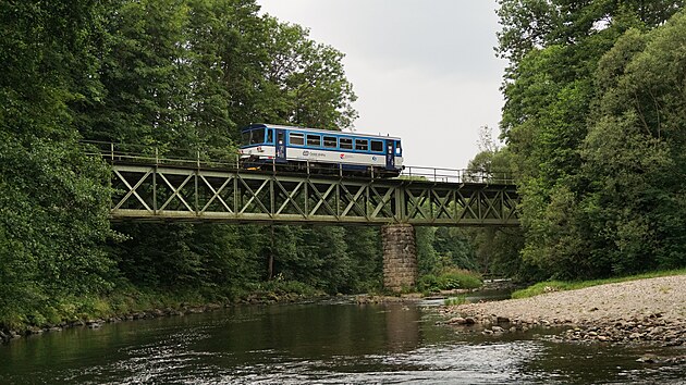 Motorov vz 810 551-2 na vlaku Os 15521 pejd pes most nad ekou Jizerou a zanedlouho zastav v malebn zastvce Horn Sytov. Vyfoceno 14. ervence 2022.