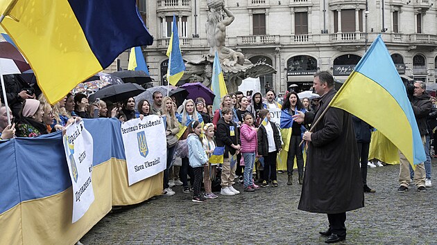 Lidé s ukrajinskými vlajkami a nápisem "Vítejte, prezidente. Sláva Ukrajině" se...