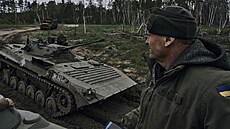 Ukrajinský voják se dívá na projídjící APC poblí ruských pozic u Kreminny v...
