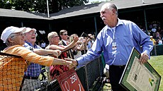 Bývalý výte�ný australský tenista Owen Davidson zdraví fanou�ky poté, co byl v...