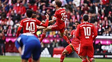 Thomas Müller slaví se spoluhrái první gól v zápase proti Schalke 04.
