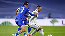 Eden Hazard z Realu Madrid drí mí ped dotírajícími hrái Getafe.