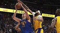 Nikola Joki� z Denveru úto�í na ko� Los Angeles Lakers, brání ho Anthony Davis.