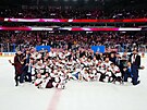 Lotytí hokejisté si dávají týmové foto s bronzovými medailemi.