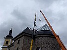 Jeřáb stěhuje skla na střechu kostela v Neratově