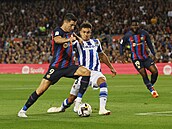 Barcelonský útoník Robert Lewandowski (vlevo) se dostává do ance pes obránce...