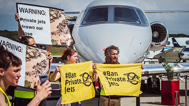 Aktivist dr transparenty bhem demonstrace proti soukromm letadlm na Evropsk obchodn leteck konferenci a vstav (EBACE 2023) v enev. (23. kvtna 2023)