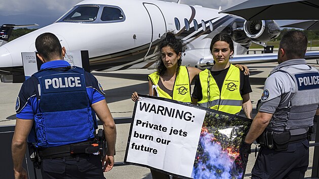Aktivist dr transparenty vyzvajc k zkazu soukromch letadel bhem demonstrace na Evropsk obchodn leteck konferenci a vstav (EBACE 2023) na enevskm letiti. (23. kvtna 2023)