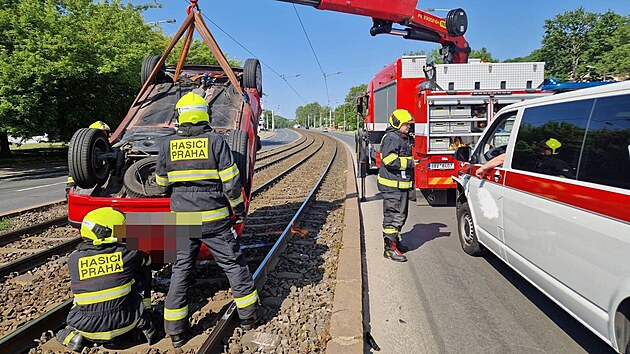 Zásah pražských hasičů si v pátek dopoledne vyžádala nehoda auta a převozové sanity v ulici Plzeňská. Po nárazu auto skončilo na střeše v tramvajových kolejích. (26. května 2023)