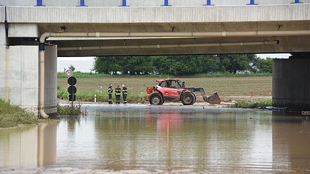 Hasiči odklízejí následky úterní bleskové povodně v otrokovické části Kvítkovice. Snímek je z dálničního podjezdu. (květen 2023)