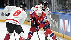 Norský kapitán Ken Andre Olimb se probíjí mezi bránícími Kana�any Codym Glassem...