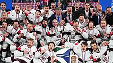Lotyšští hokejisté si dávají týmové foto s bronzovými medailemi.