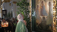 Ruská vící se modlí u Ikony Svaté Trojice Andreje Rubljova. (3. ervna 2012)