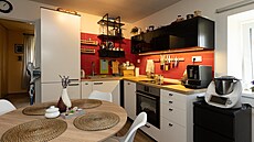 Interiér kuchyně je laděný do černé, bílé a červené barvy.