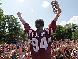 Kristians Rubins slaví s pohárem ped lotyskými fanouky.