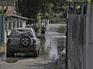 Místní obyvatel jde po ulici, která byla zaplavena poté, co ruská vojska v noci...