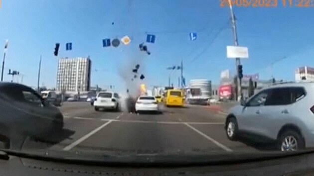 Trosky létají nad silnicí během raketového útoku Ruska na Ukrajinu v Kyjevě na snímku ze sociální sítě. (29. května 2023)
