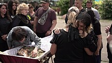 Manelka a matka ukrajinského vojáka se objímají u jeho rakve na hbitov v...