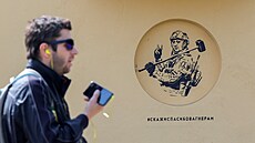 Muž v Petrohradě prochází kolem graffiti, které zobrazuje zakladatele Wagnerova...