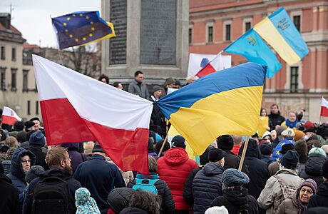 Lidé ve Varav mávají polskou a ukrajinskou vlajkou bhem shromádní na...
