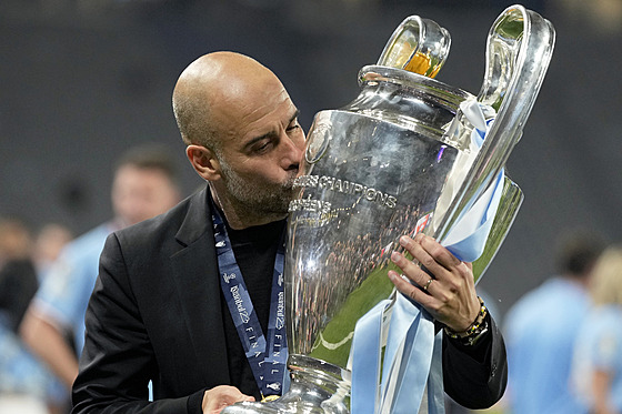 panlský trenér fotbalového Manchesteru City Pep Guardiola se laská s trofejí...