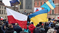Lidé ve Varav mávají polskou a ukrajinskou vlajkou bhem shromádní na...