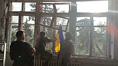 Ukrajintí vojáci stojí ped svou vlajkou v budov bhem operace, na jejím...