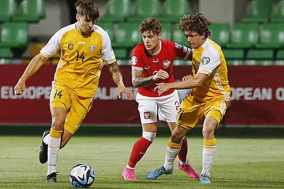 Polský fotbalista Nicola Zalewski (uprostřed) v souboji s Moldavany Arturem...