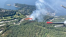 Letecký snímek hasiského letadla, které shazuje protipoární látku na poár u...