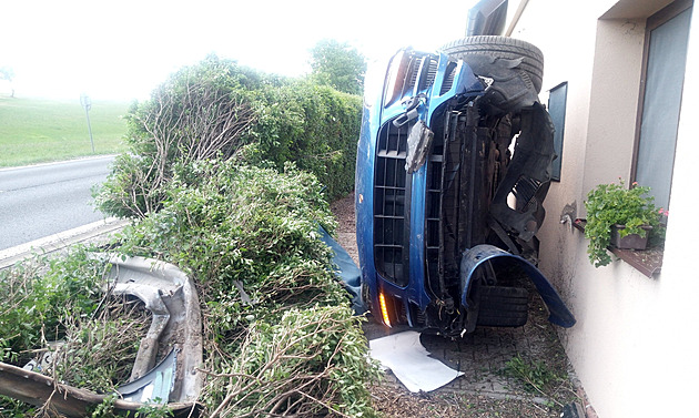 Řidič na Náchodsku proletěl keřem a „přilepil“ porsche podvozkem na dům