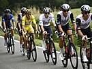 Prbný lídr Tour de France Adam Yates (ve lutém) se veze za svým kolegou,...