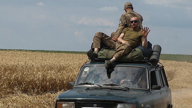 Ukrajint vojci jedou na stee auta po silnici pobl nedvno dobyt vesnice Novodarivka. (3. ervence 2023)