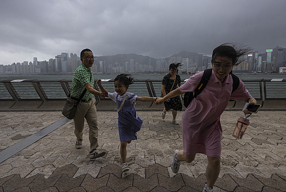 Turisté bí bí po promenád v Hong Kongu, kolem kterého se pehnal tajfun...