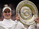 Markéta Vondrouová pózuje s trofejí pro ampionku Wimbledonu.
