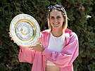 Wimbledonská ampionka Markéta Vondrouová pózuje na praské tvanici s trofejí.