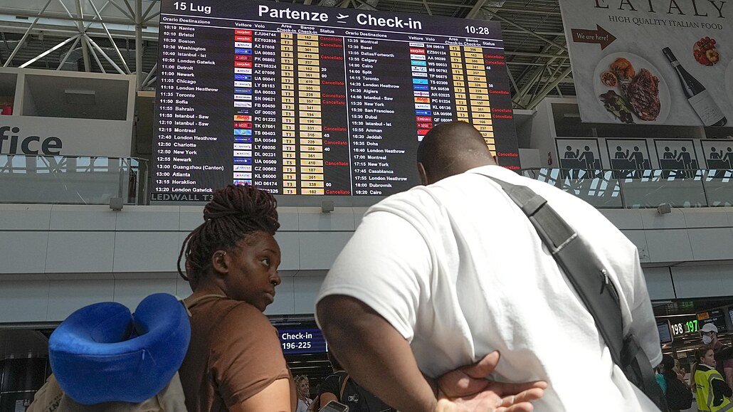 Cestující sledují monitor na ímském mezinárodním letiti Fiumicino bhem...