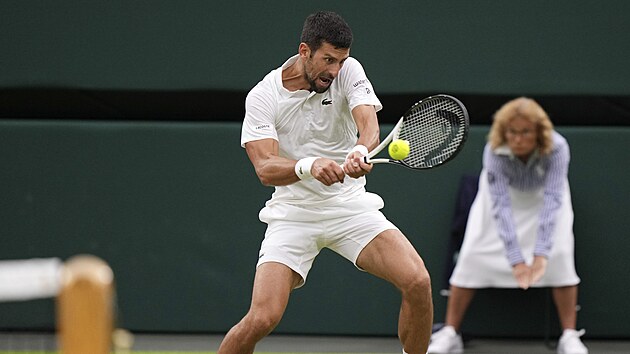 Srbsk tenista Novak Djokovi hraje bekhend v semifinle Wimbledonu.