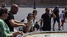 Lidé se snaží zchladit u fontány na Piazza del Popolo v Římě. (14. července...
