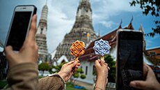 Lidé si fotí zmrzliny ve tvaru dladic u slavného Chrámu úsvitu v Bangkoku. (8....