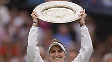 Markéta Vondroušová zvedá trofej pro vítězku Wimbledonu.