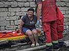 Ukrajintí hasii a záchranái pracují na míst zniené budovy po ruském...