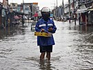 Lidé se brodí zaplavenou ulicí po tajfunu Doksuri ve Valenzuele na Filipínách....