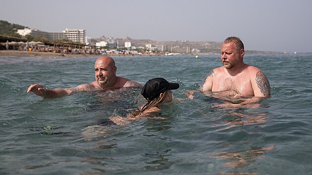 et turist Vclav Ztka (vpravo) s dcerou Annou a kamardem Markem Koudelkou se vera koupali u ple Galazio Beach na Rhodosu. (26. ervence 2023)