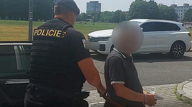 Policista vede zadr�en�ho mu�e, obvin�n�ho z okraden� 93let�ho seniora, k jedn�n� o vzet� do vazby. (26. �ervence 2023)