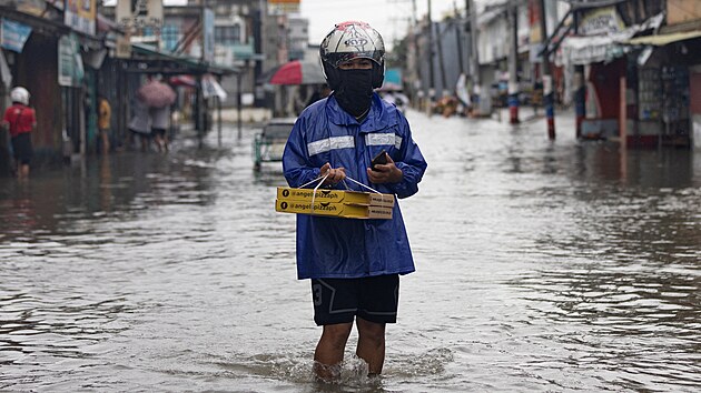 Lid se brod zaplavenou ulic po tajfunu Doksuri ve Valenzuele na Filipnch. (27. ervence 2023)