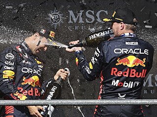 Max Verstappen (vpravo) zkrápí v Belgii �ampa�ským Sergia Péreze, svého par�áka...
