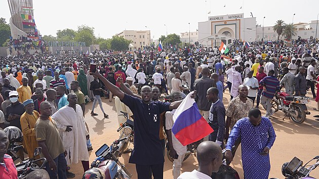 Demonstranti drží ruskou vlajku a transparenty během shromáždění na podporu pučistů v hlavním městě Niamey v Nigeru. (30. července 2023)