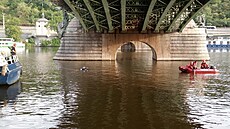 Hasiči a policisté hledají pod Čechovým mostem člověka (30. července 2023).