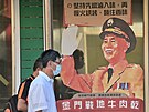 Obyvatelé tchajwanského souostroví in-men procházejí kolem portrétu generála...